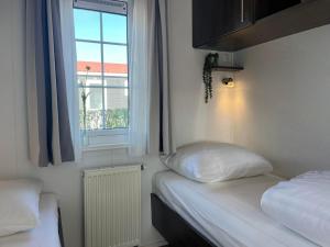 two beds in a room with a window at Chaletverhuur-Olmenduin in Serooskerke