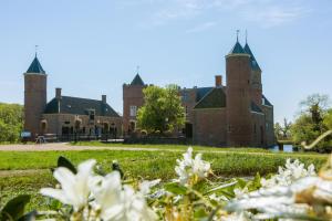 a large brick building with two towers at Chaletverhuur-Olmenduin in Serooskerke