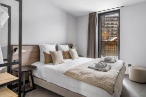 a bedroom with a large white bed with a window at Les Chalets du Grand Hôtel in Saint-Chaffrey