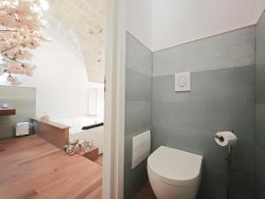 a bathroom with a white toilet and a sink at Olympus Luxury Suites Menotti in Mola di Bari