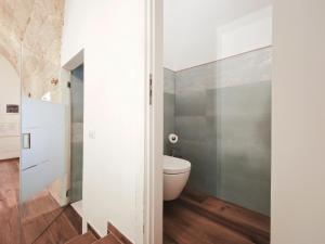 a bathroom with a toilet and a wall at Olympus Luxury Suites Menotti in Mola di Bari