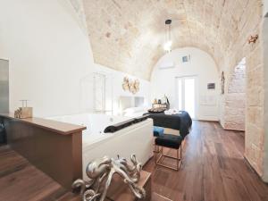 a bathroom with a tub and a table in a room at Olympus Luxury Suites Menotti in Mola di Bari