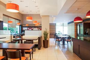 a dining room with tables and chairs and windows at Ibis Barcelona Mollet in Mollet del Vallès
