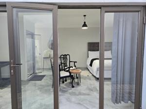 a bedroom with a bed and a chair and a table at Cjabaledi Private Guesthouse in Centurion
