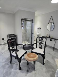 a room with two chairs and a table and a mirror at Cjabaledi Private Guesthouse in Centurion