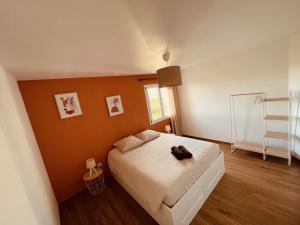 a bedroom with a bed with a black bag on it at Villa Alba in Auménancourt-le-Petit