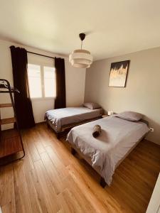 a bedroom with two beds and a large window at Villa Alba in Auménancourt-le-Petit
