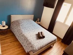 a bedroom with a bed with a pair of shoes on it at Villa Alba in Auménancourt-le-Petit