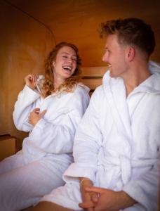 a man and a woman sitting in a bed at Floating Village Brombachsee in Ramsberg +62 photos