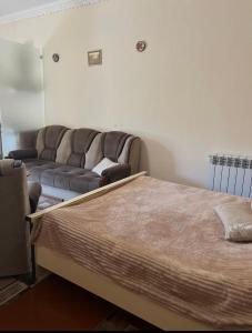 a bedroom with a bed and a couch in it at Norik guest house in Garni