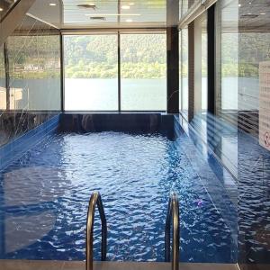 a large swimming pool with a view of the water at Chuncheon Onda Poolvilla in Chuncheon