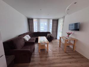 a living room with a couch and a table at Domek Premium in Tleń