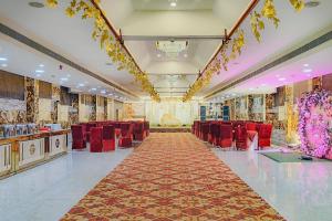 a banquet hall with red chairs and a long corridor at Treebo Maple Delite in Lucknow