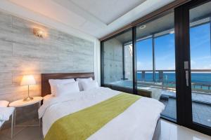 a bedroom with a bed with a view of the ocean at Goseong Romiet Pension in Goseong