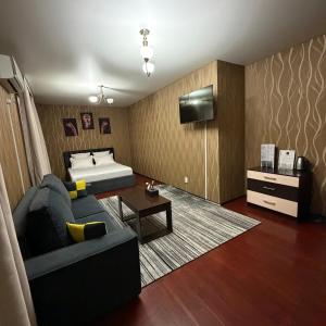 a living room with a couch and a bed at Hotel Mansuri in Almaty