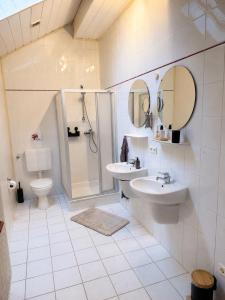 a bathroom with two sinks and a shower and a toilet at Apartment Auszeit in Ulrichstein +17 photos