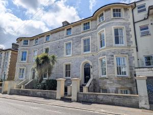 a large stone building with a palm tree in front of it at Sandlands - Perfect central location in Ryde