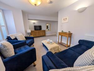 a living room with two blue couches and a tv at Sandlands - Perfect central location in Ryde