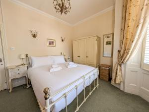 a bedroom with a bed with two towels on it at Sandlands - Perfect central location in Ryde