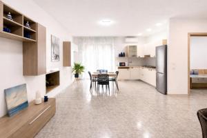 a kitchen and dining room with a table and chairs at Center Room Tortolì wifi, AC, free parking, city center at 100 m in Tortolì +19 photos
