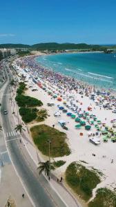 an aerial view of a beach with many umbrellas at Lisboa Hospedaria 300 m da praia do forte in Cabo Frio