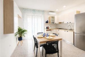 a kitchen with a table and chairs in a kitchen at Center Room Tortolì wifi, AC, free parking, city center at 100 m in Tortolì