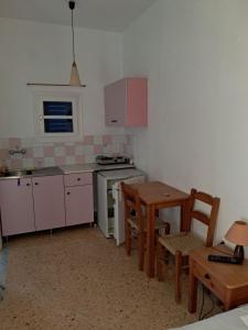 a kitchen with a table and a table and chairs at Pyrgis Glyfades studios in Glifades +1 photo