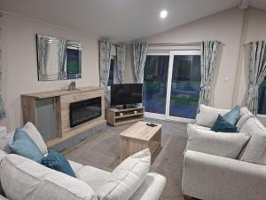 a living room with two couches and a television at Crescent Lodge in Forton