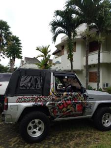 a white jeep parked in front of a house at Dieng Puri Homestay in Diyeng +7 photos
