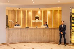 a man in a suit standing at a counter at Majestic Central Hotel in Dubai +25 photos