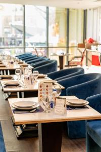 a row of tables in a restaurant with blue chairs at Majestic Central Hotel in Dubai