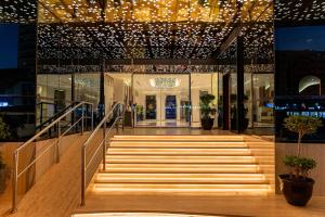 a lobby of a building with stairs and lights at Majestic Central Hotel in Dubai