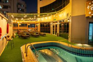 a hotel with a pool and a patio with lights at Majestic Central Hotel in Dubai