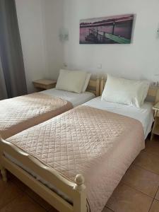 two beds sitting next to each other in a room at Galini Pension in Ios Chora