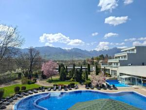 a resort with a pool and mountains in the background at Spa Hotel Ata in Varshets