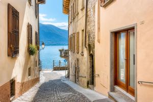 an alleyway between buildings with a view of a lake at 2 Min zum Lago Maggiore, Modernes & Zentrales Apartment in Cannobio