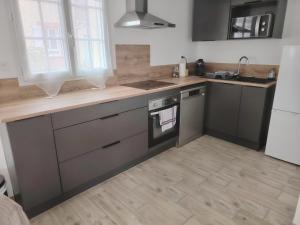 a kitchen with stainless steel appliances and wooden floors at Jauxvial 1 in Jaux