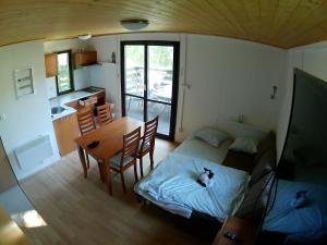 a room with a bed and a table and a kitchen at Chaty u Martiny in Nalžovice