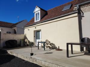 a white house with a patio with a table at Jauxvial 1 in Jaux