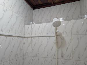 a shower with a light on a white marble wall at Baobab Lodge Douala - Makepe in Douala +40 photos