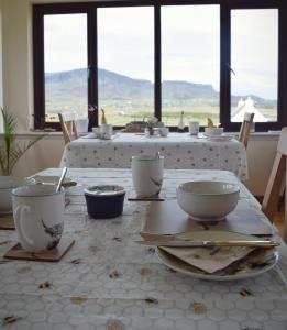 a table with bowls and plates on it with a view at Benview House in Staffin