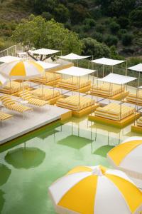 ein Haufen Stühle und Sonnenschirme im Wasser in der Unterkunft Doryssa Lithos Hotel in Pythagoreio