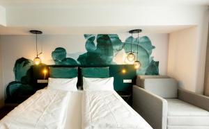 a hotel room with a bed and a couch at DORMERO Hotel Freiburg in Freiburg im Breisgau +12 photos