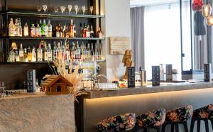 a bar with a shelf of liquor bottles at DORMERO Hotel Freiburg in Freiburg im Breisgau