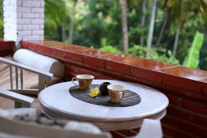 una mesa con dos tazas de café encima en Danaya's Cottage and Studio en Ubud