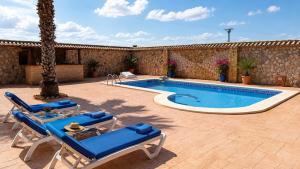 a swimming pool with blue lounge chairs and a table at La Casona del Olivo - Pool, Patio, BBQ & Pet-Friendly in Torre-Pacheco