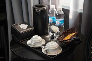 a tray with a tea set on a table with water bottles at Madelise Ensora Hotel & Travel in Hanoi