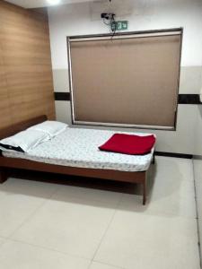 a bed in a room with a red blanket on it at Balaji rooms&domentry in Surat