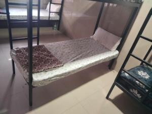 a small bed in a room with two bunk beds at Balaji rooms&domentry in Surat +1 photo
