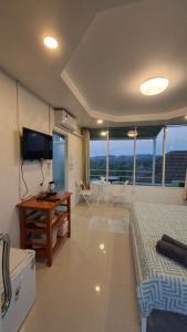 una camera da letto con un letto, una scrivania e una televisione di บ้านแช่มช้อย 360 a Khao Kho
